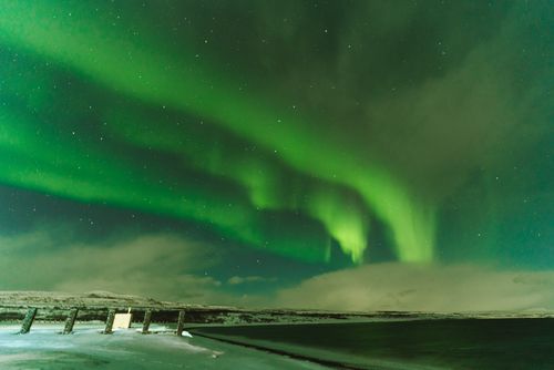 Free Stunning view of the Northern Lights dancing over a snow-covered landscape at night. Stock Photo