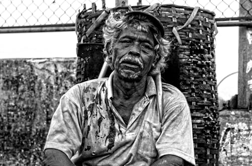 Homme En Polo Assis Près De Panier Tissé Marron Photographie Noir Et Blanc