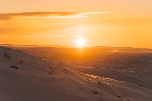 Breathtaking sunset view over a serene snow-covered mountain, capturing the essence of winter tranquility.