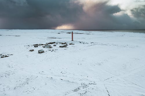 An Aerial Photography of a Snow Covered Ground Under the Gloomy Sky