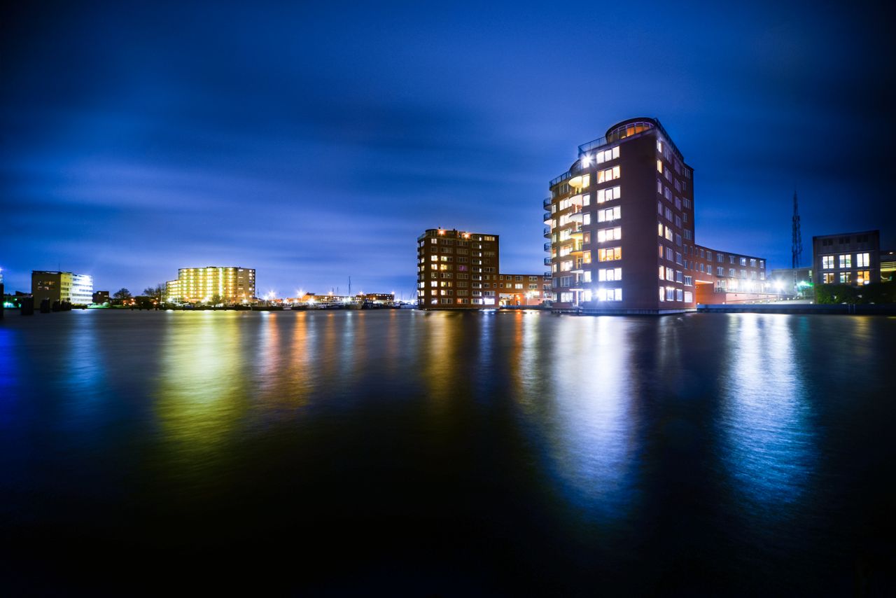 a vibrant cityscape featuring illuminated buildings reflecting on a ca