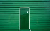 明亮的绿色木板条墙与中央木门构成了一处引人注目的建筑元素