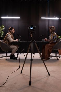 Dynamic podcast session featuring two hosts with studio lighting and recording equipment.