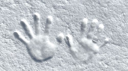 Free Close-up of two hand imprints in fresh snow, capturing winter texture. Stock Photo