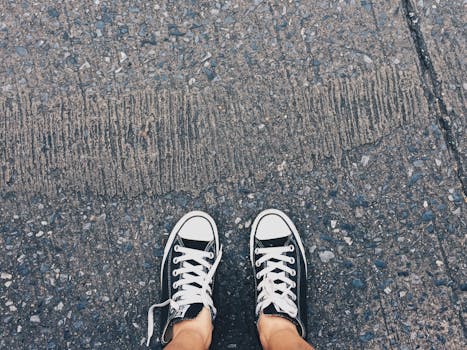 Person Showing Its Feet Wearing White Sneakers · Free Stock Photo