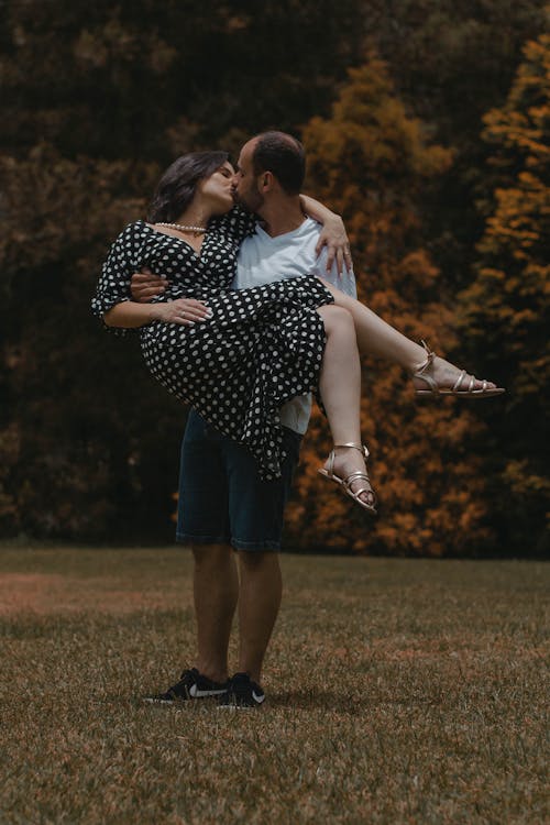Loving adult couple kissing and embracing on lawn