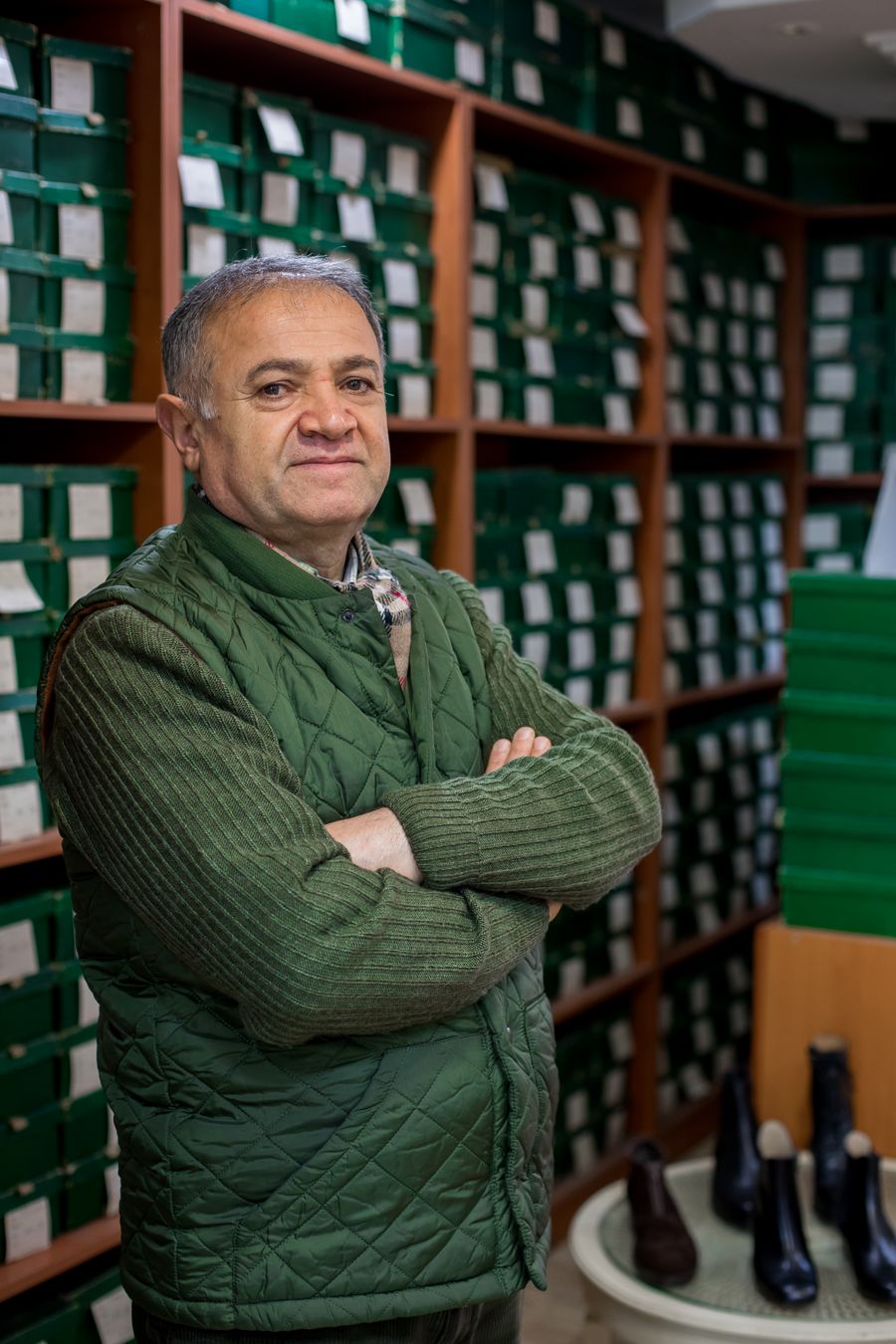 A shop owner standing with folded arms in his own shop