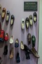Collection of handmade leather shoes hanging on wall in manufacture