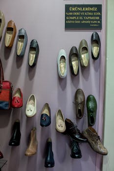 Colorful handmade leather shoes displayed on a wall inside a boutique store.