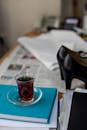 Glass of tea on papers near heels on table