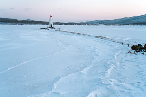 Aerial View of a Lighthouse on a Snow-Covered Field