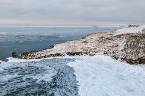 Snowy Brown Mountain Beside Body of Water