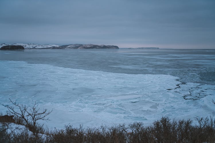 Mountain Ranges Along A Frozen Body Of Water