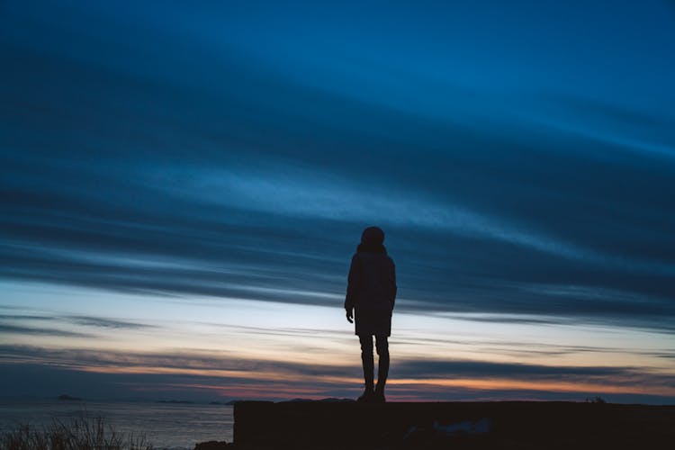 Silhouette Of A Person Standing Under A Dramatic Sky