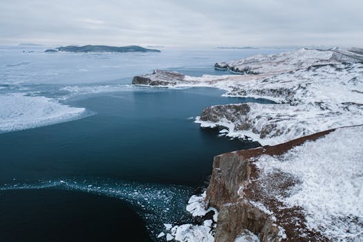 Winter coastline in Khasansky District, Russia, showcasing icy cliffs and serene sea.