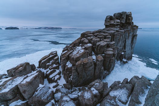 Captivating aerial view of a rocky snow-covered coastline in the Arctic during winter.