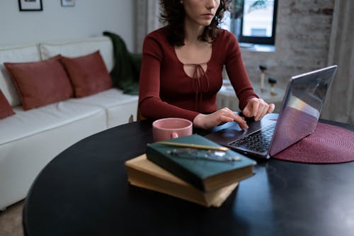 A Woman in Red Long Sleeve Shirt using Laptop