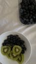 Blueberries in container and in bowl with sliced kiwi