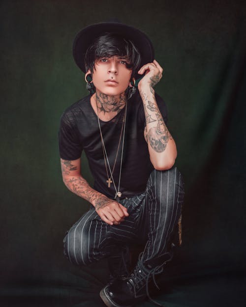 Stylish tattooed man in hat and accessories