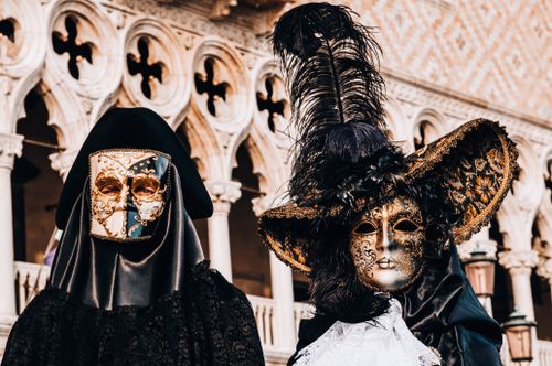 Free Intricate Venetian masks with elaborate costumes in front of historic architecture in Venice, Italy. Stock Photo