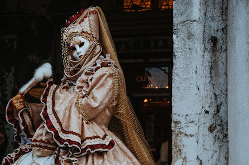 A Woman in White and Brown Dress Wearing Mask