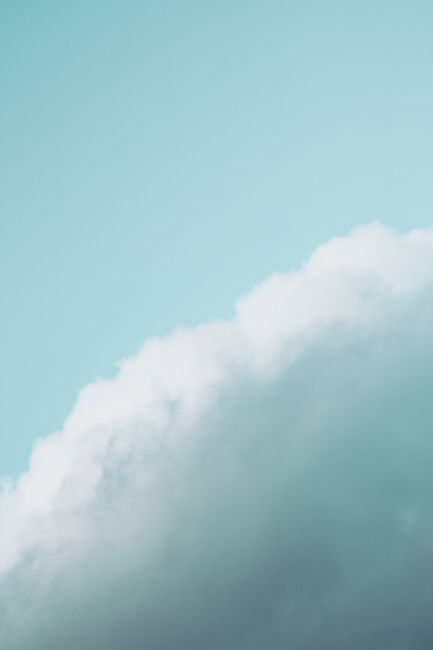 Breathtaking view of white fluffy uneven cumulus cloud floating on blue sky in daylight