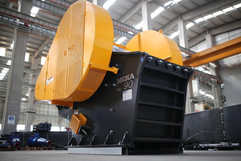 High-angle image of a jaw crusher machine inside a modern industrial manufacturing plant