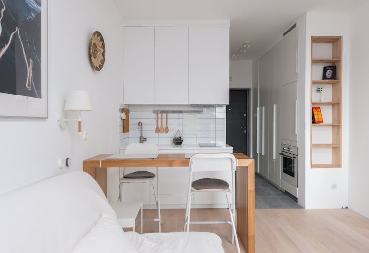 Comfortable Sofa Placed Near Wooden Counter And Kitchen In Apartment