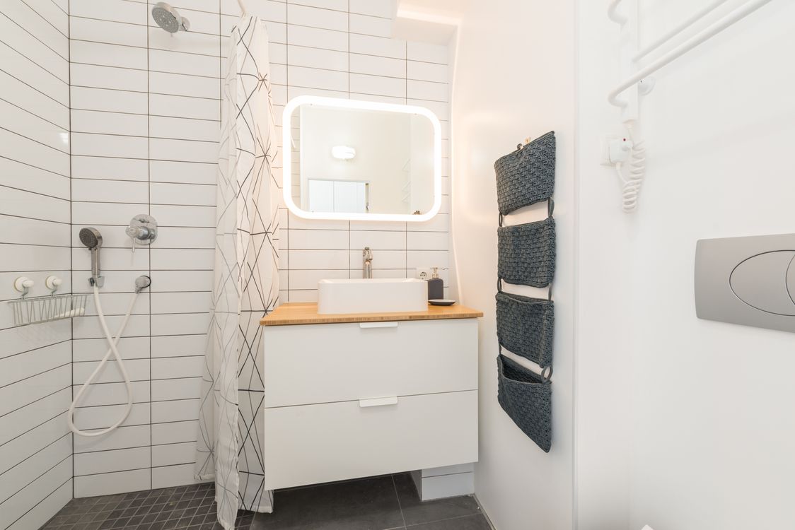 Minimalist bathroom with shower cabin and white furniture and ...