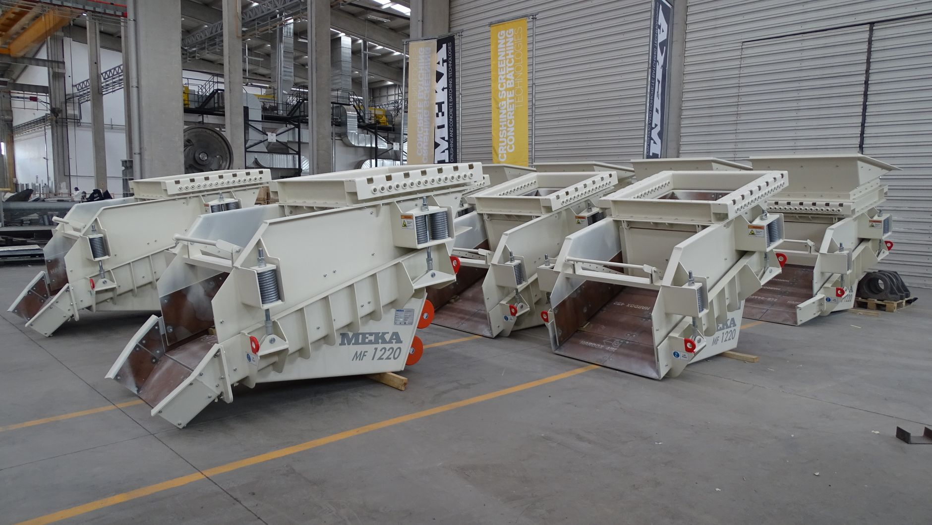 Row of heavy-duty industrial machinery inside modern factory facility.