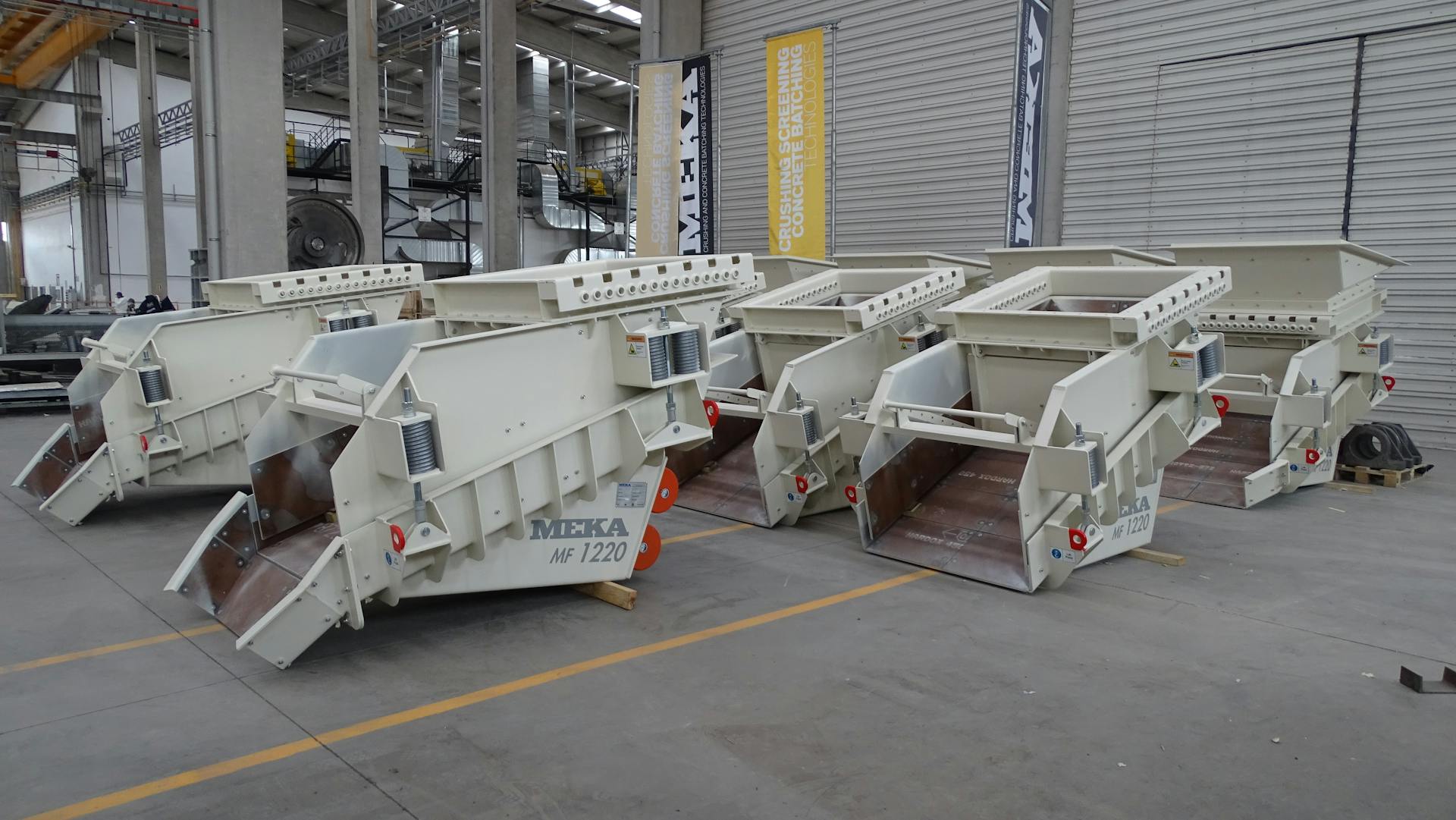 Row of heavy-duty industrial machinery inside modern factory facility.