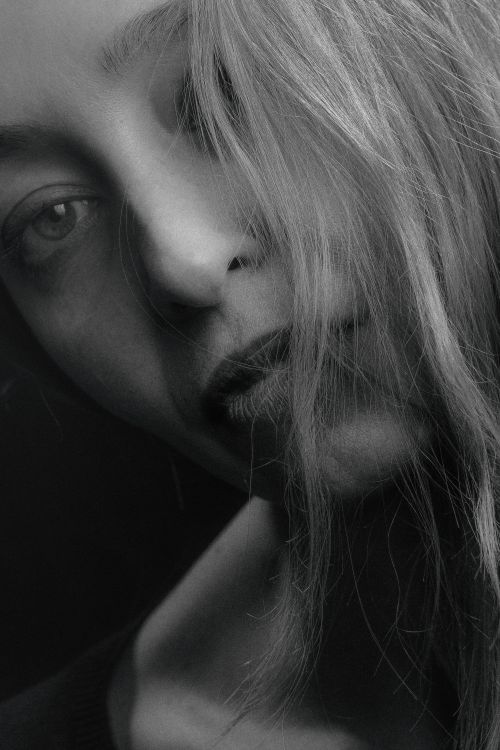 Free Close-up black and white portrait of a contemplative woman with blonde hair. Stock Photo