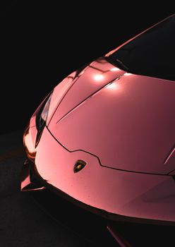 Close-up of a luxurious pink Lamborghini supercar with sleek design and elegance.