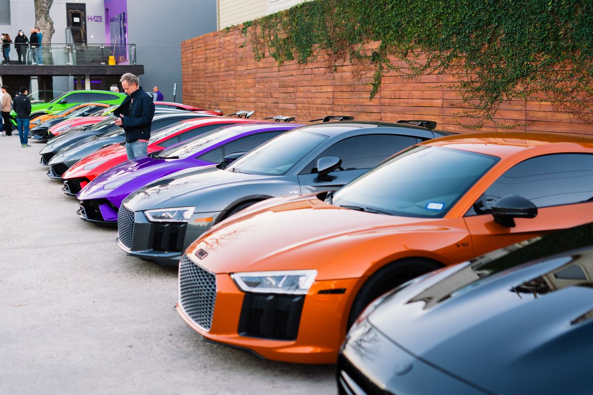 Luxury sports cars lined up at an outdoor car gathering