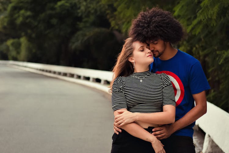 Happy Diverse Couple Embracing On Road