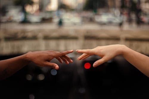 Diverse couple touching hands on street