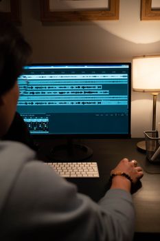 Sound engineer editing audio tracks on a computer monitor in a modern recording studio.