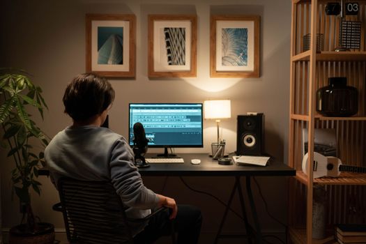 Sound engineer working on audio production in a modern home studio setup.