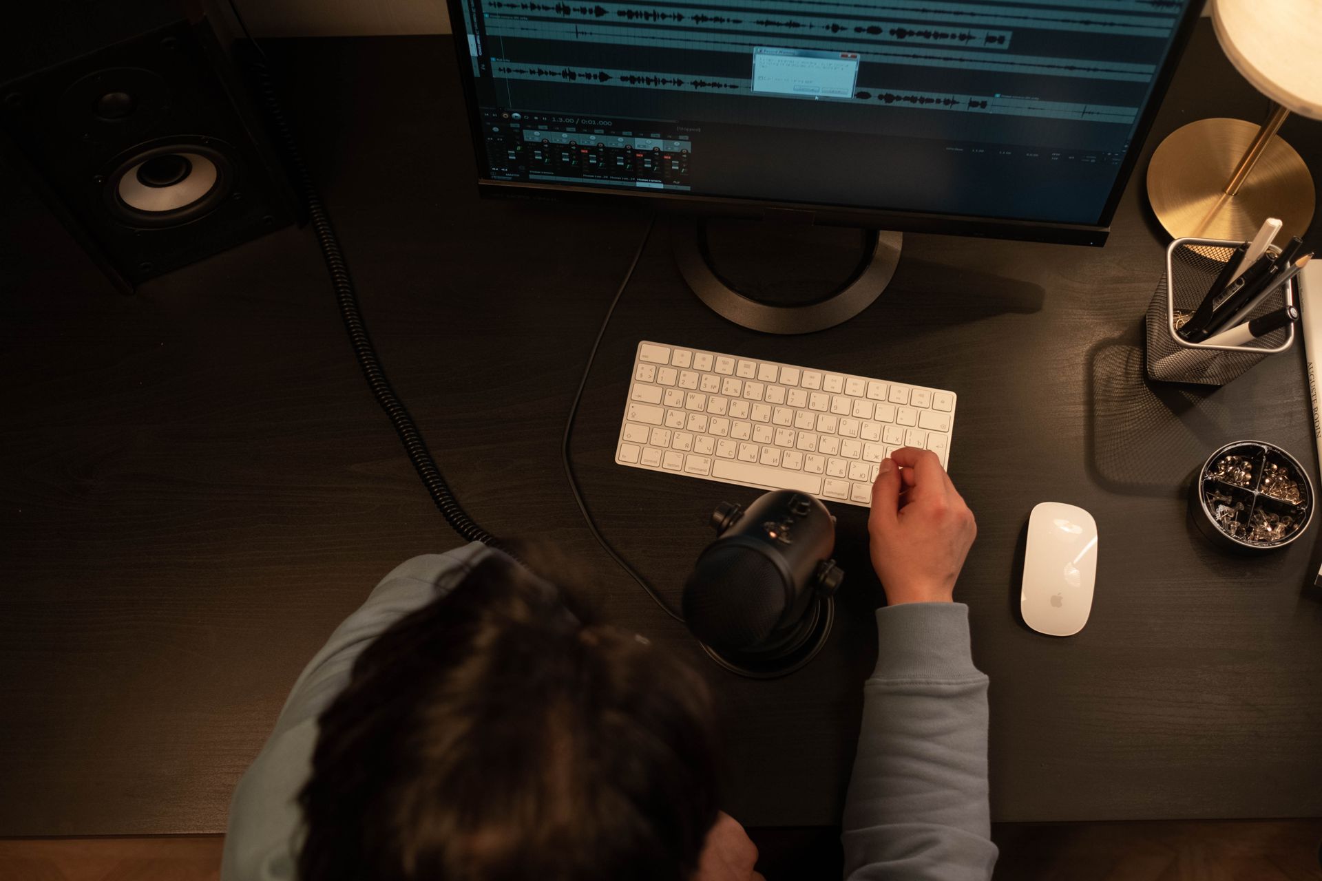 An overhead view of a sound engineer working on a recording project with computer peripherals in a studio.