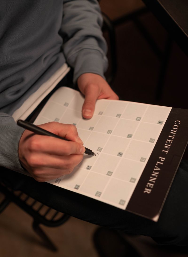 Hand writing notes on a paper calendar planner