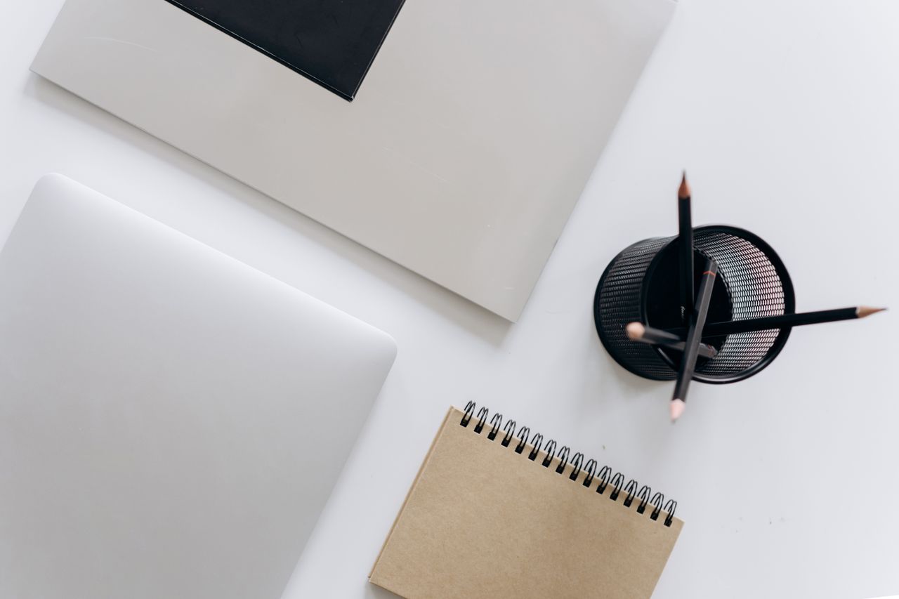 top view of a minimalist workspace featuring a laptop notepad and stat