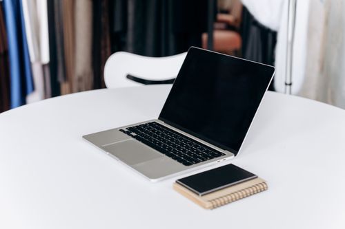 Free Open laptop and notebook on a stylish white table in an office setting. Stock Photo
