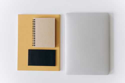 Free Flat lay of a closed laptop, notebook, and tablet on neutral surface. Stock Photo