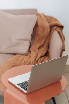 A serene indoor setup featuring a laptop on a side table, perfect for a cozy workspace setting.