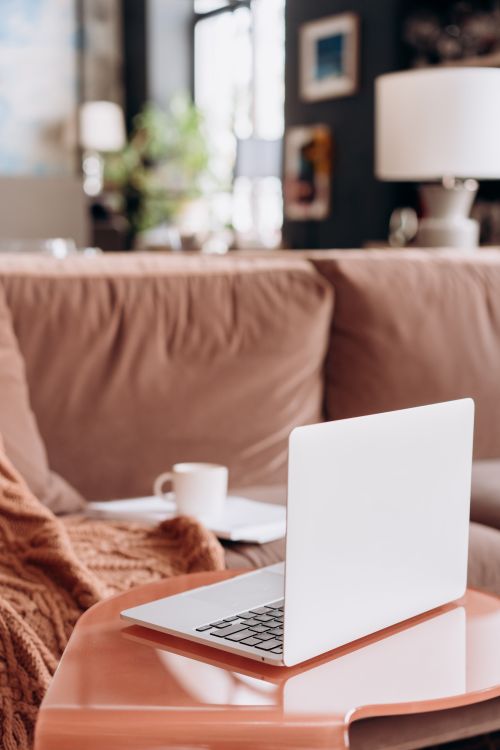 Free A stylish living room setup with a laptop on a table, perfect for home office inspiration. Stock Photo