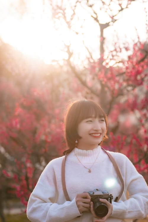 Pretty Woman in White Sweater Holding a Camera