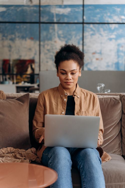 Free Casual workspace environment with woman using a laptop. Ideal for mobile work concept. Stock Photo