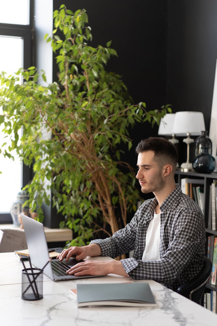 Side View Of A Man Using Laptop