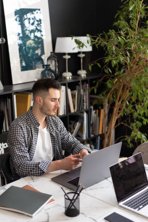 Free A male professional working on a laptop in a contemporary home office setting. Stock Photo
