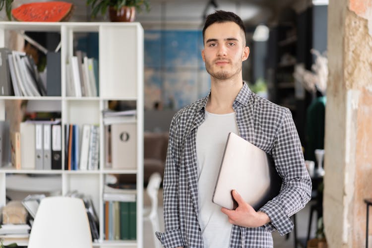 A Man Carrying A Laptop